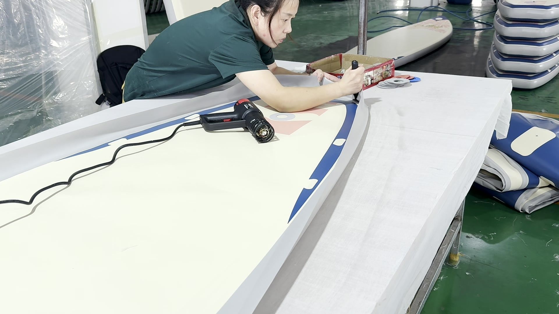 Worker pressing an inner rail along a board seam.