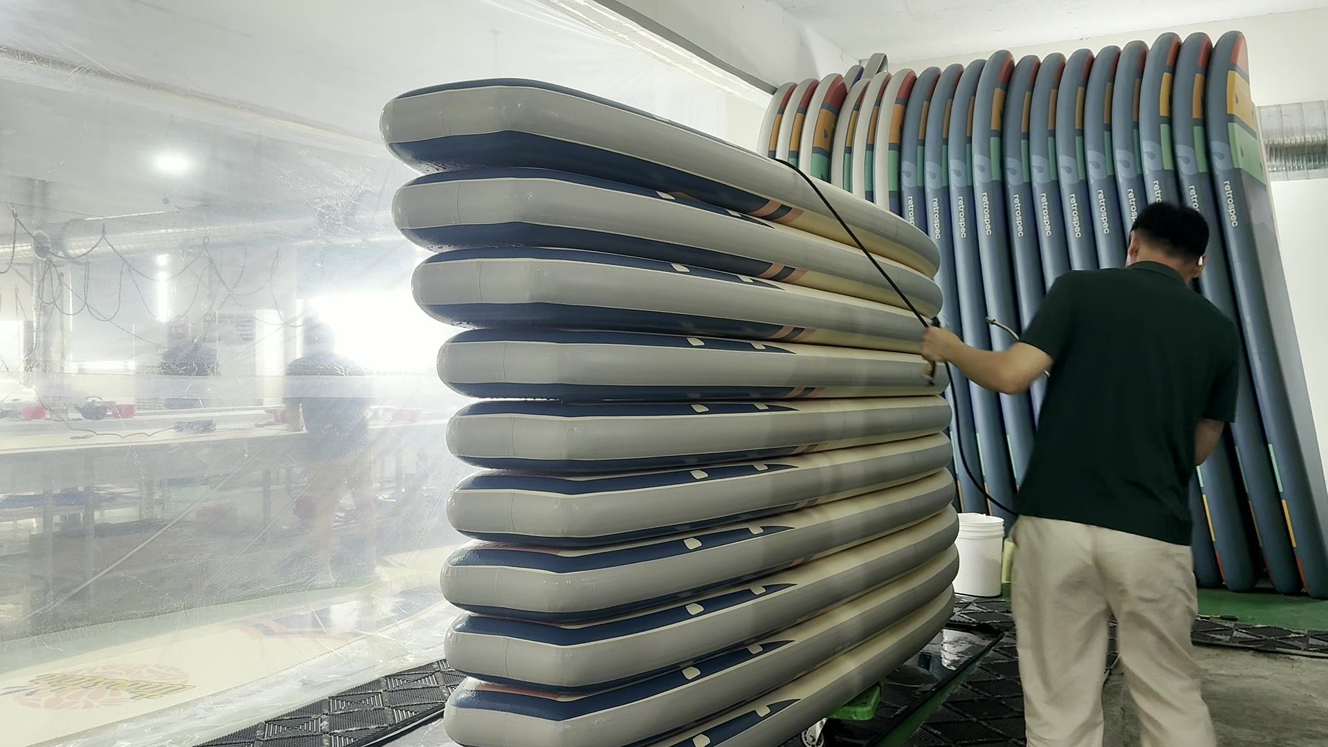Worker hosing down a stack of boards during the leak test.