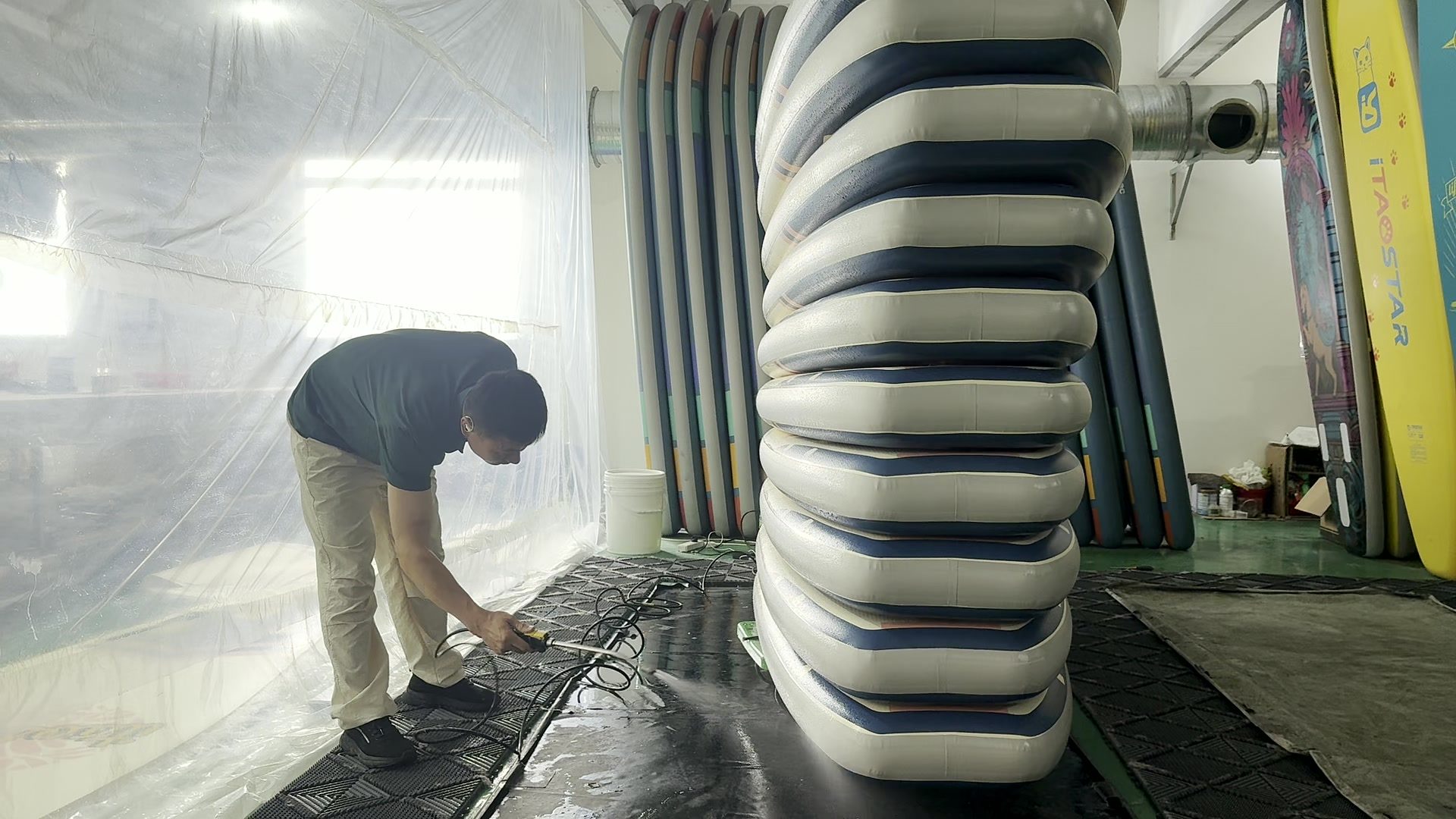 Operator working a hose along a stack of boards.